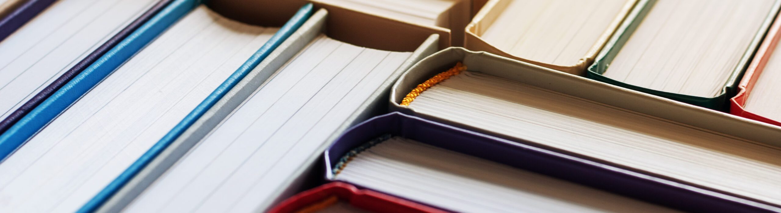 Background of hardbound books arranged in stacks in bookstore, selective focus